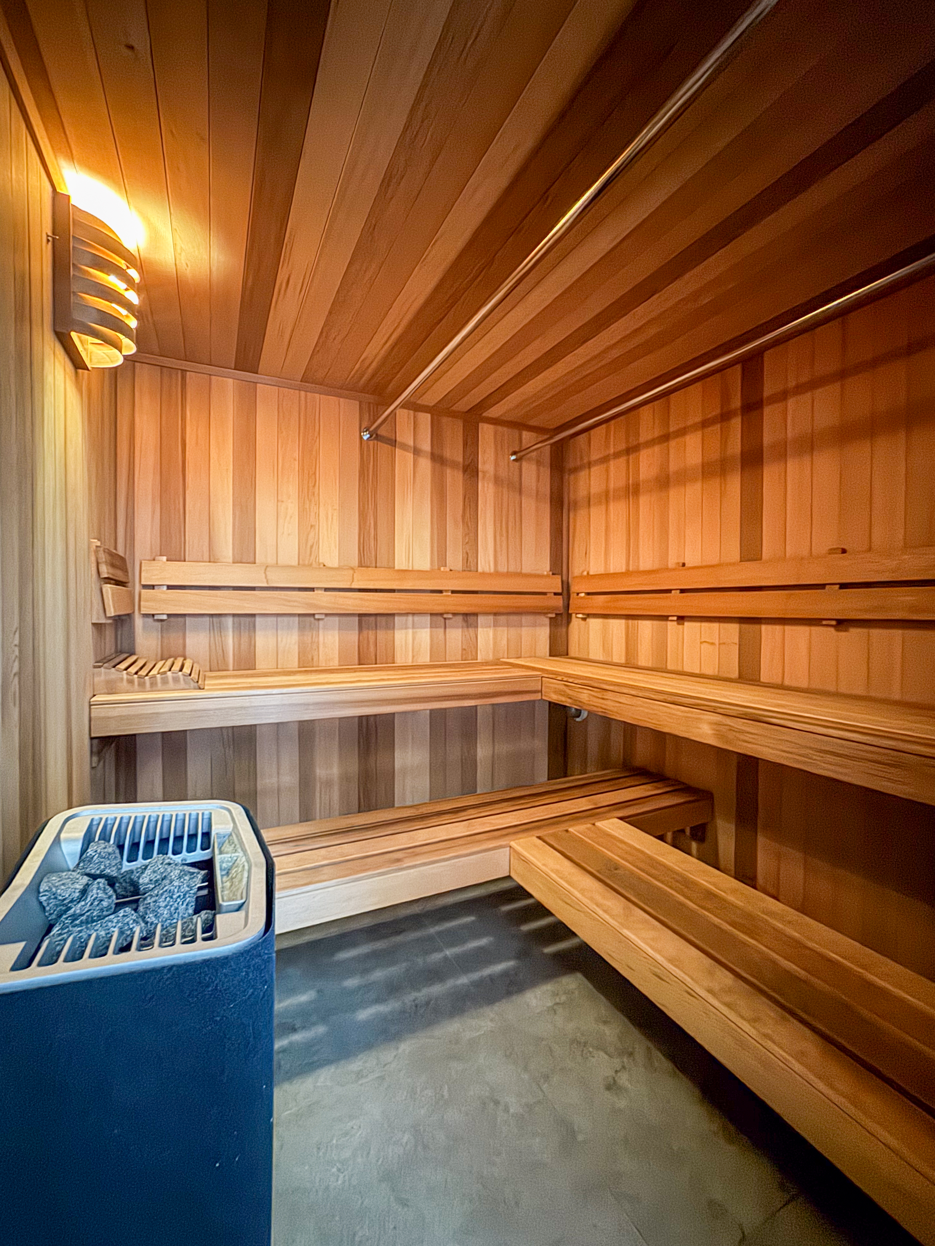 Cedar-lined sauna with multi-level benches and electric heater